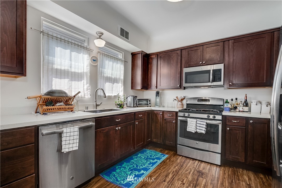 834 15th Avenue Seattle, WA 98122 - Photo 11 of 23 a kitchen with stainless steel appliances granite countertop a sink stove and microwave