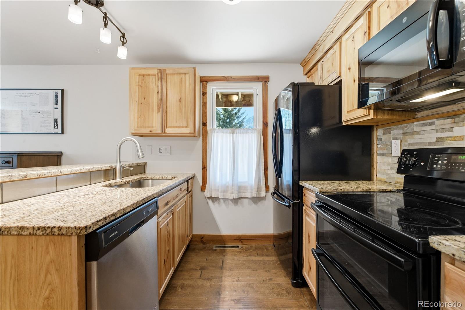1463 Main Street Georgetown, CO 80444 - Photo 16 of 47 a kitchen with a granite countertop sink stove and refrigerator