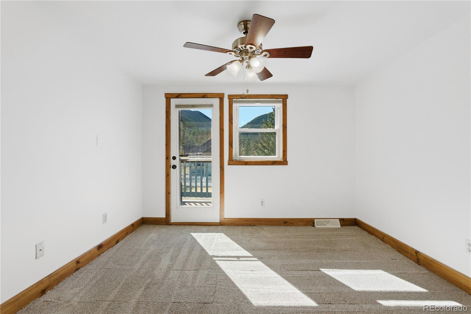 1463 Main Street Georgetown, CO 80444 - Photo 19 of 47 an empty room with a ceiling fan and windows