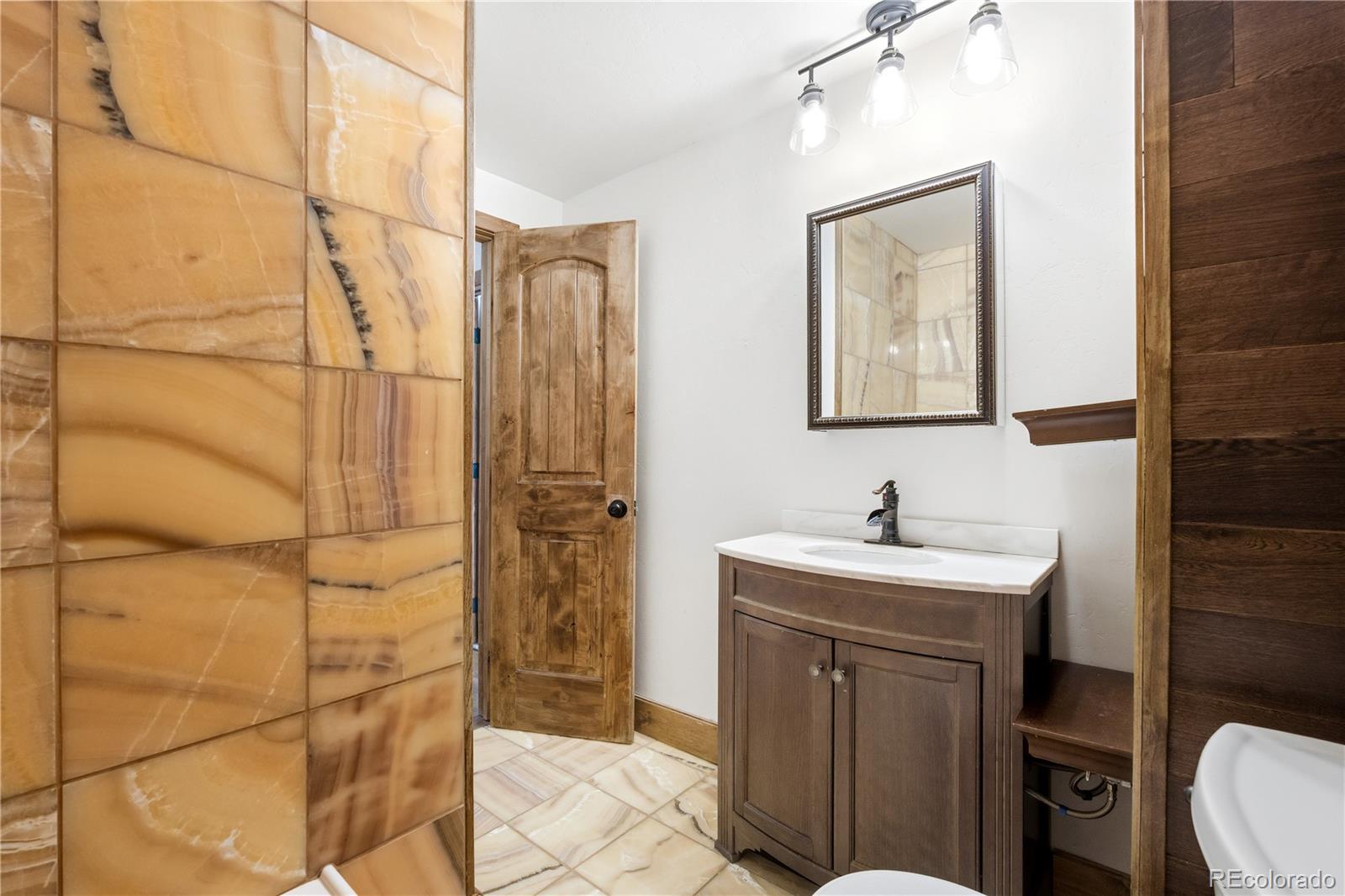 1463 Main Street Georgetown, CO 80444 - Photo 25 of 47 a bathroom with a sink a toilet and mirror