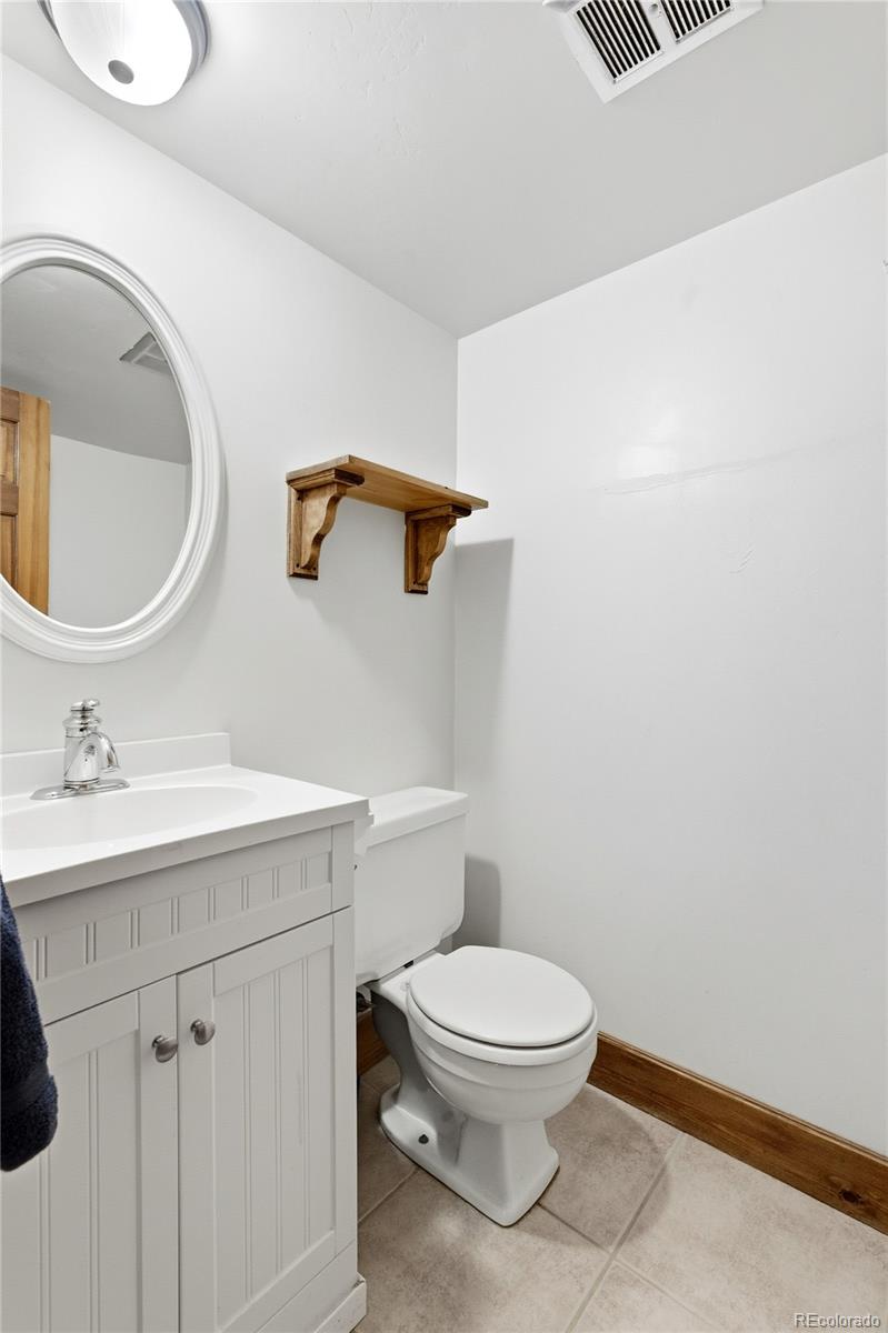 1463 Main Street Georgetown, CO 80444 - Photo 31 of 47 a bathroom with a toilet a sink and mirror