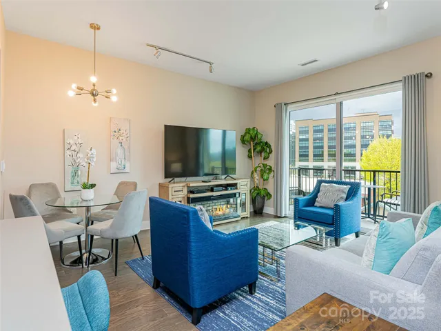 a living room with furniture a flat screen tv and a large window