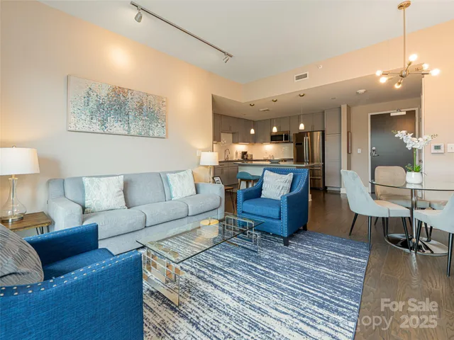 a living room with furniture and a dining table with wooden floor