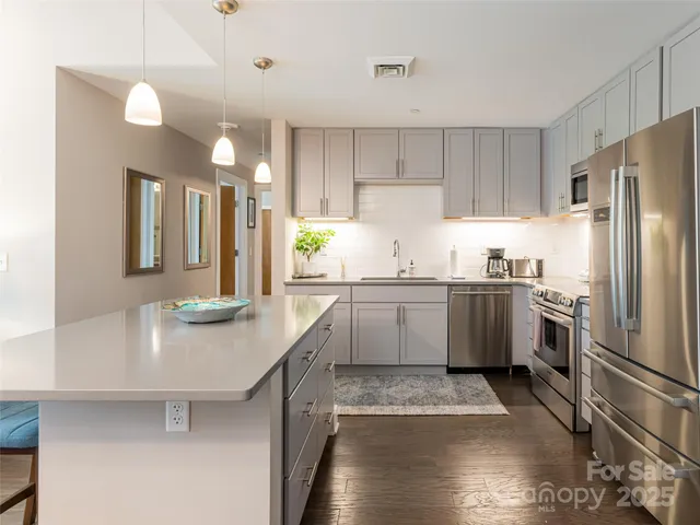 a kitchen with a sink a counter top space stainless steel appliances and cabinets