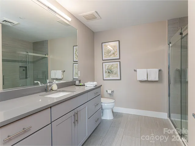 a bathroom with a granite countertop sink a toilet and a mirror
