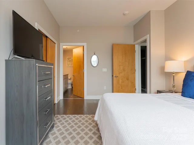 a bedroom with a bed and a flat screen tv