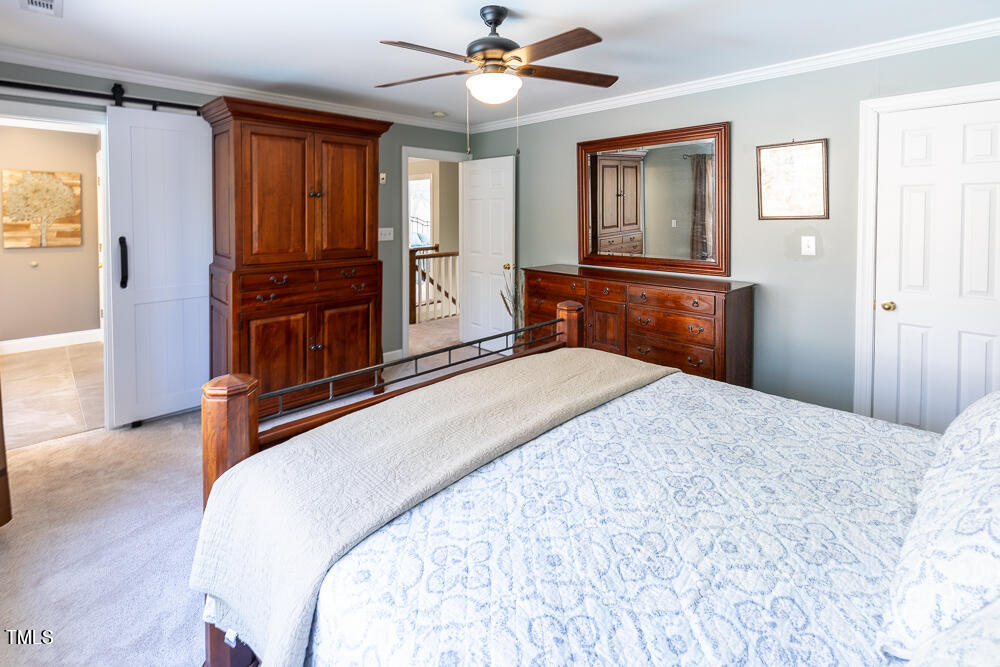 5924 North Hawthorne Way Raleigh, NC 27613 - Photo 23 of 45 a bedroom with a bed and a chandelier