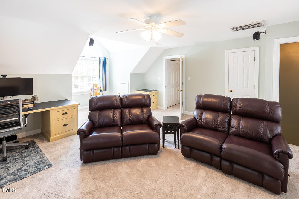 5924 North Hawthorne Way Raleigh, NC 27613 - Photo 32 of 45 a living room with furniture a ceiling fan and a window