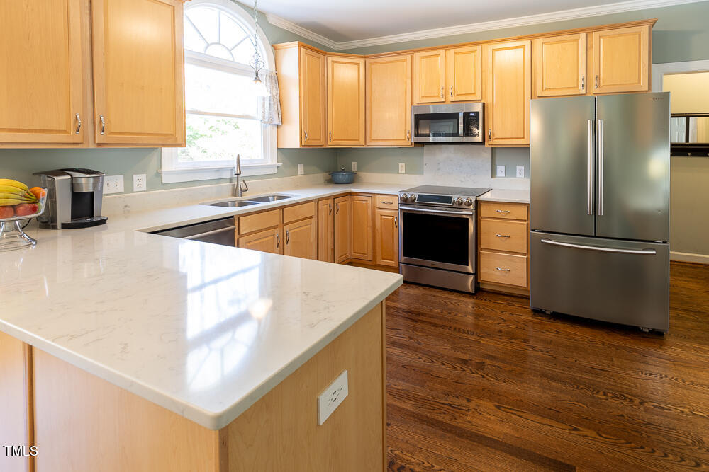 5924 North Hawthorne Way Raleigh, NC 27613 - Photo 9 of 45 a kitchen with a refrigerator a stove a sink and a window