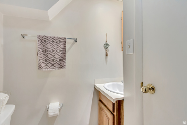 65 West 700 North Bountiful, UT 84010 - Photo 27 of 29 Bathroom vanity featuring a light wood-finish cabinet and an integrated white sink