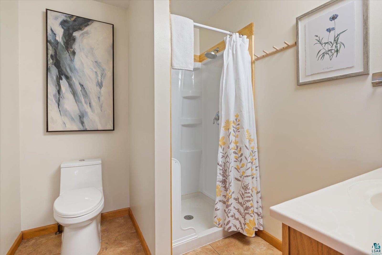 6266 Giants Ridge Road Biwabik, MN 55705 - Photo 24 of 37 Bathroom featuring a white toilet, stand-up shower with white surround, and a vanity with an integrated sink