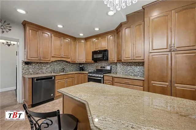 a kitchen with stainless steel appliances granite countertop a stove refrigerator and microwave