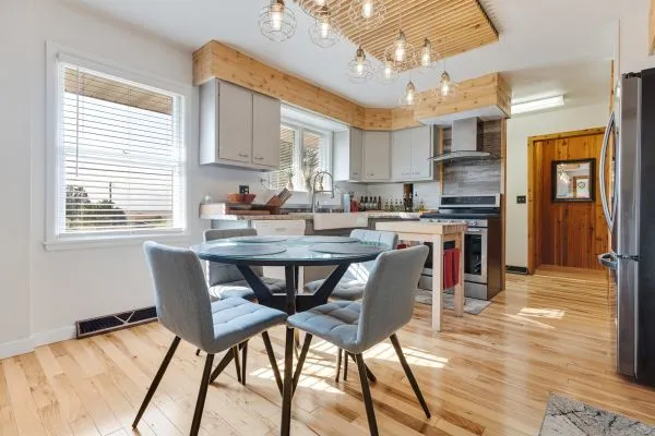 a dining room filled chandelier and wooden floor