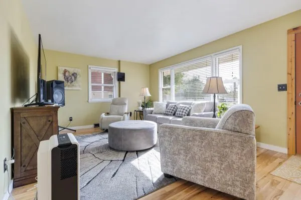 a living room with fireplace furniture and a large window