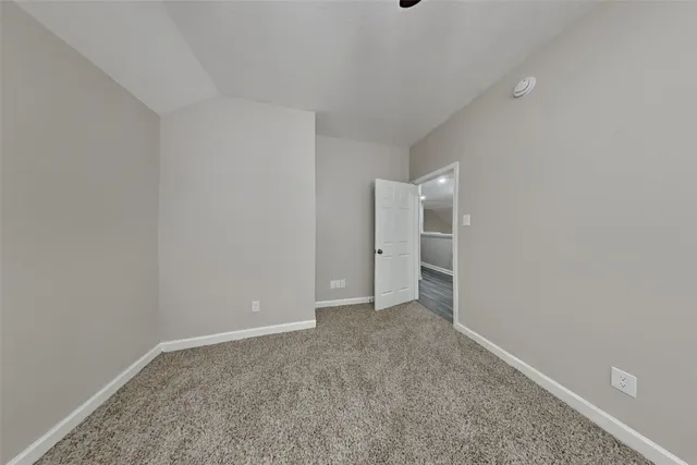 a view of an empty room with closet and a window