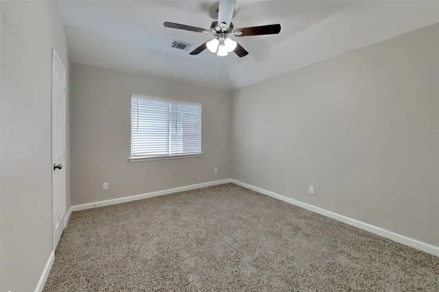 an empty room with windows and fan