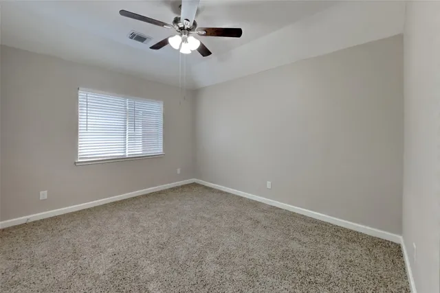 a view of empty room with ceiling fan