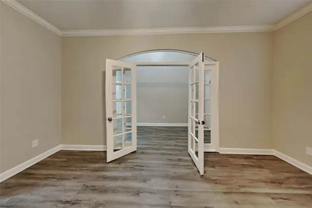 an empty room with wooden floor and entrance