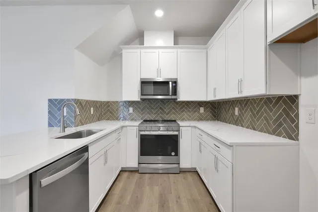 a kitchen with stainless steel appliances granite countertop a sink and a microwave
