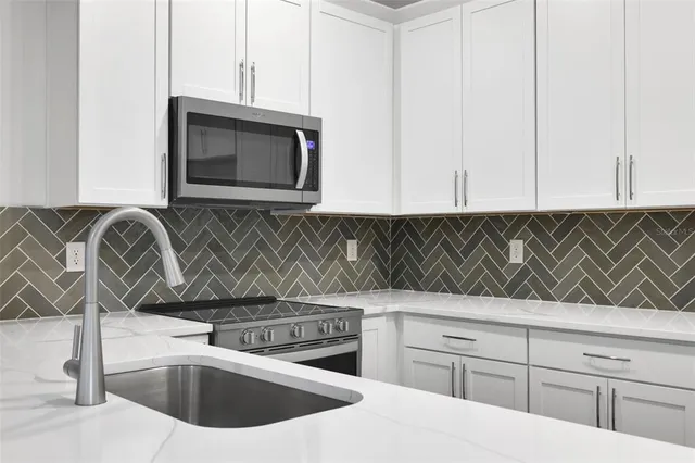 a kitchen with kitchen island white cabinets appliances and sink