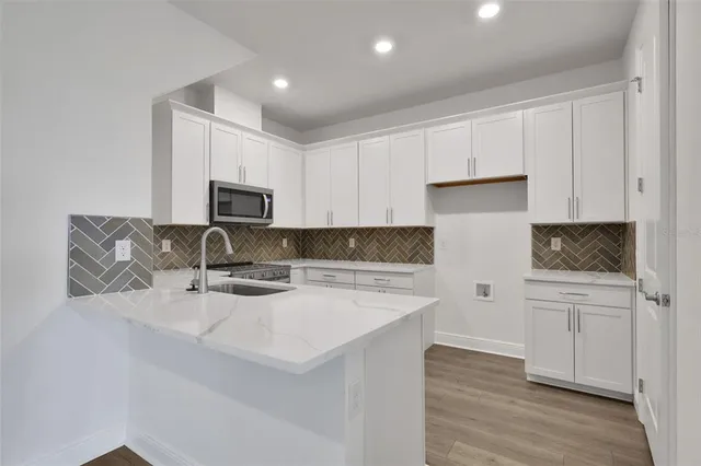 a kitchen with white cabinets and sink
