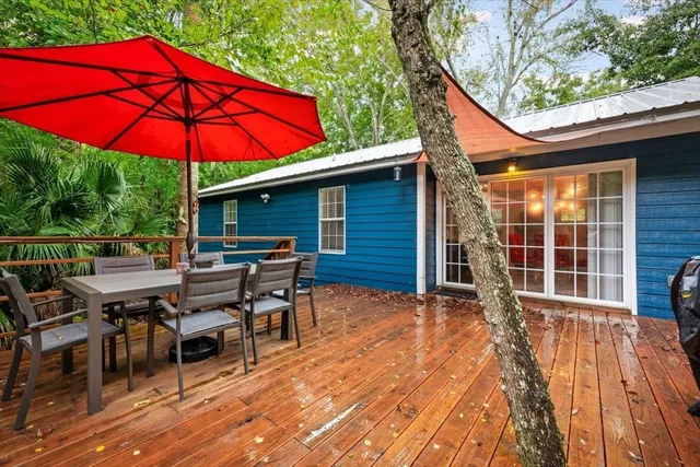 a patio with wooden floor a yard a table and chairs