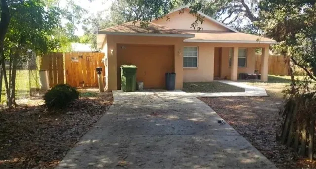 a front view of a house with a yard and tree