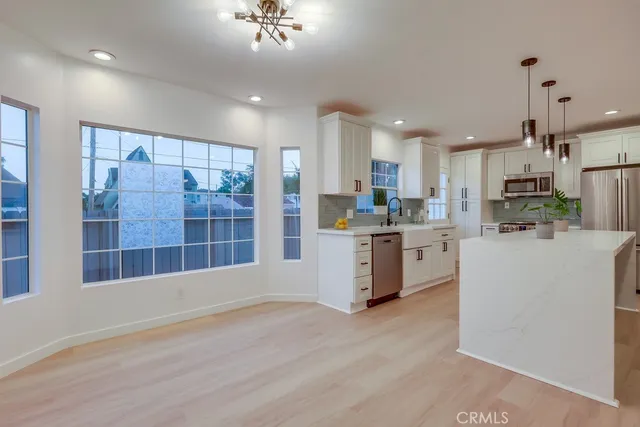 a kitchen with stainless steel appliances granite countertop a stove a sink and a refrigerator