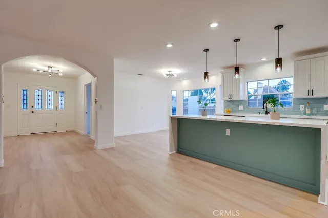 a living room with furniture a dining table and chairs with wooden floor