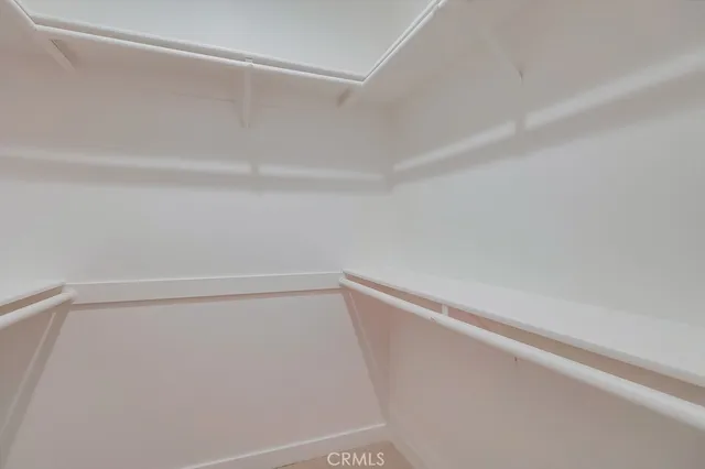 a view of an empty room with a window and fireplace