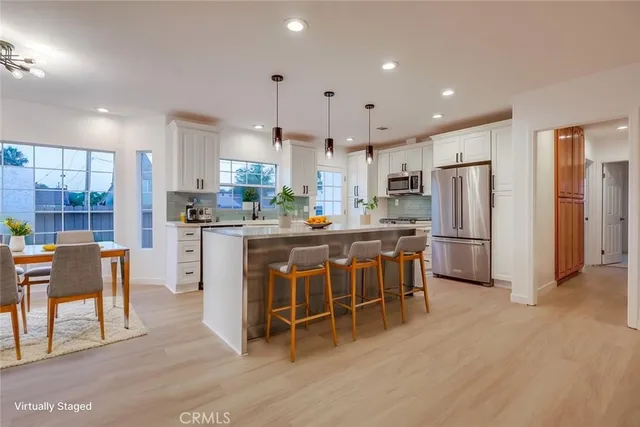 a kitchen with stainless steel appliances kitchen island granite countertop a sink stove and refrigerator