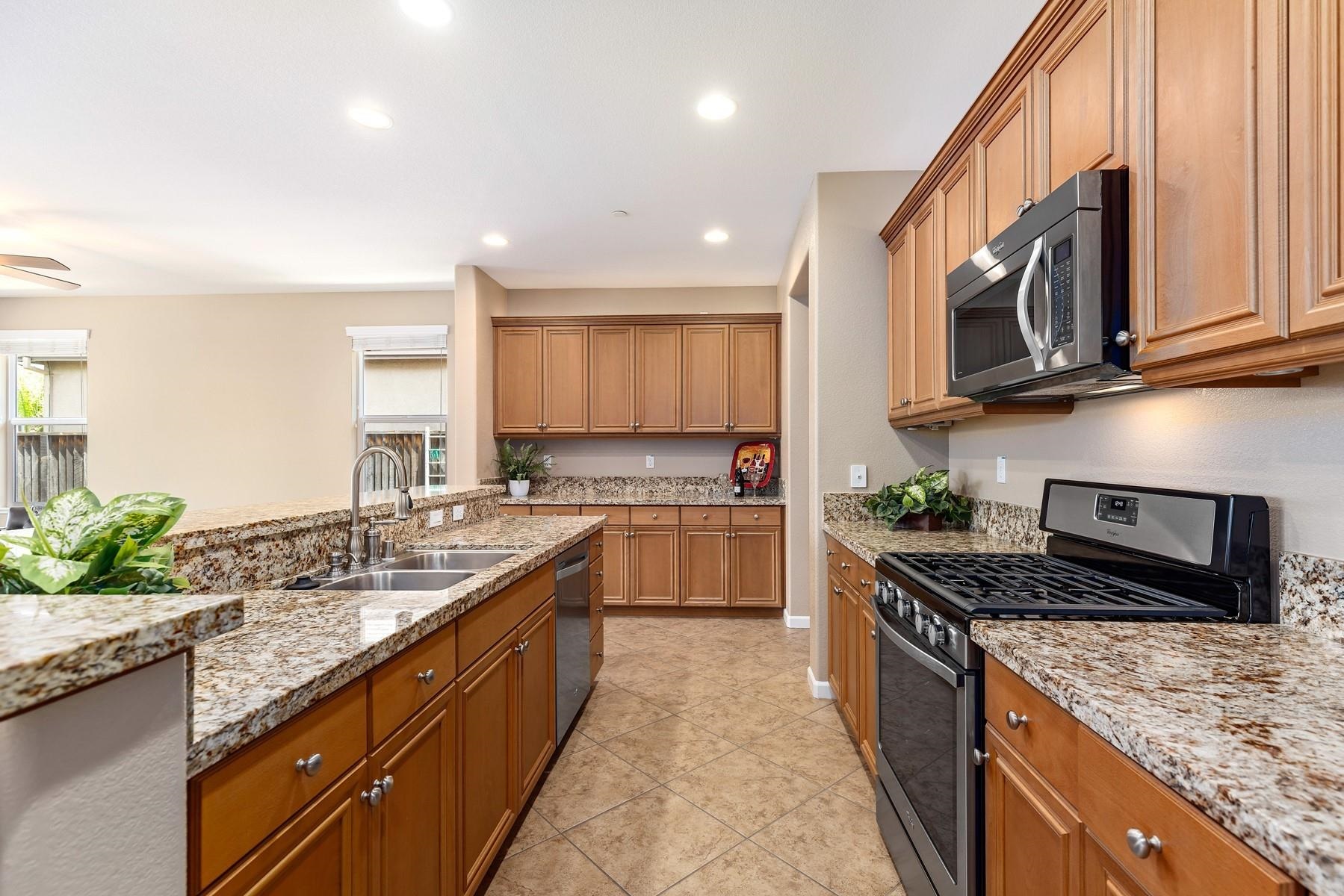 9901 Pyramid Way Discovery Bay, CA 94505 - Photo 15 of 53 a kitchen with stainless steel appliances granite countertop a stove a sink and a microwave