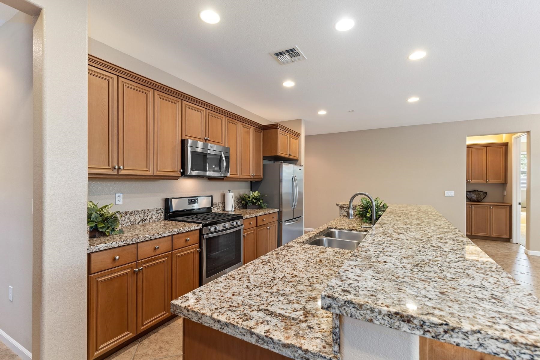 9901 Pyramid Way Discovery Bay, CA 94505 - Photo 17 of 53 a kitchen with stainless steel appliances granite countertop sink stove refrigerator and cabinets