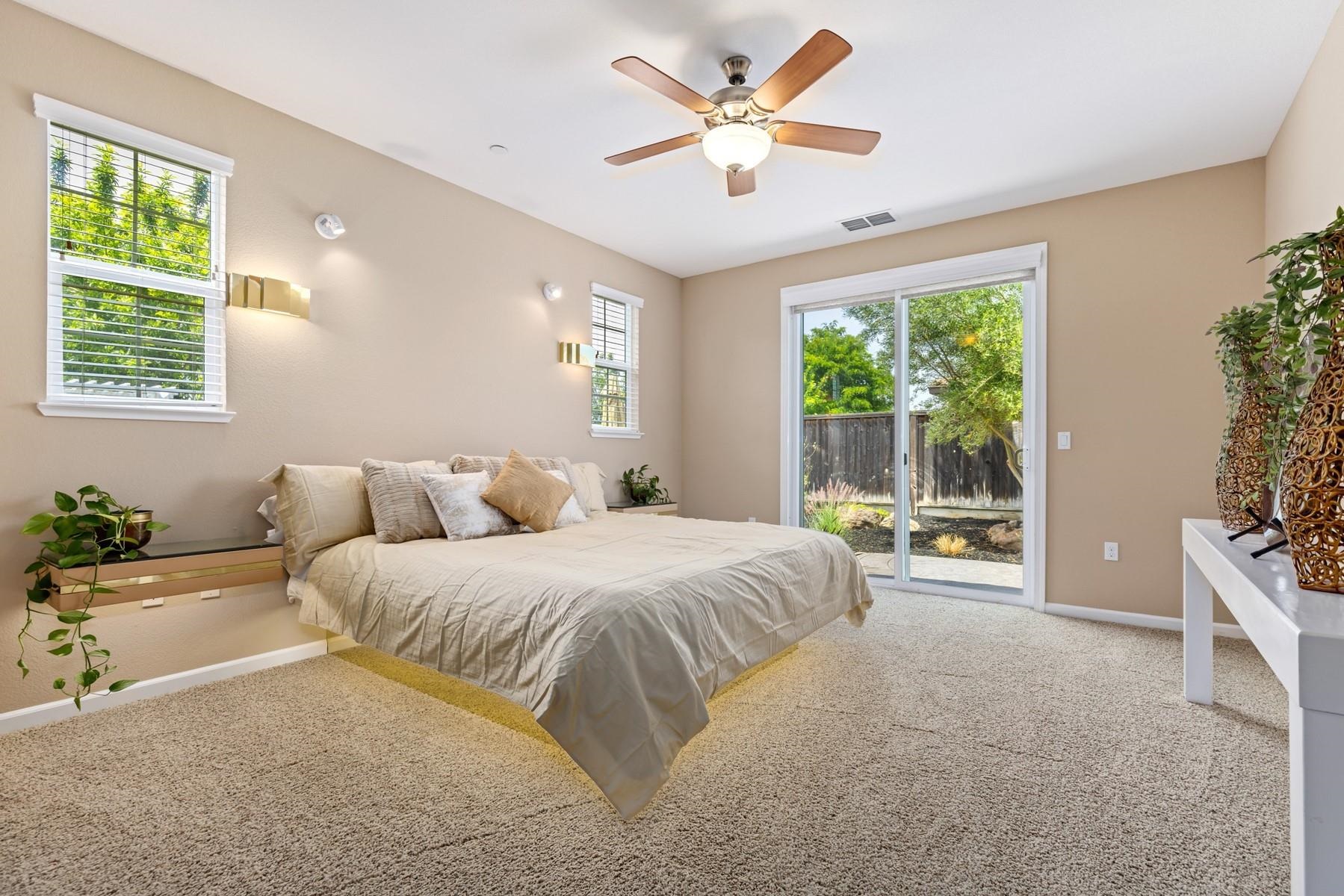 9901 Pyramid Way Discovery Bay, CA 94505 - Photo 23 of 53 a spacious bedroom with a large bed and a chandelier fan