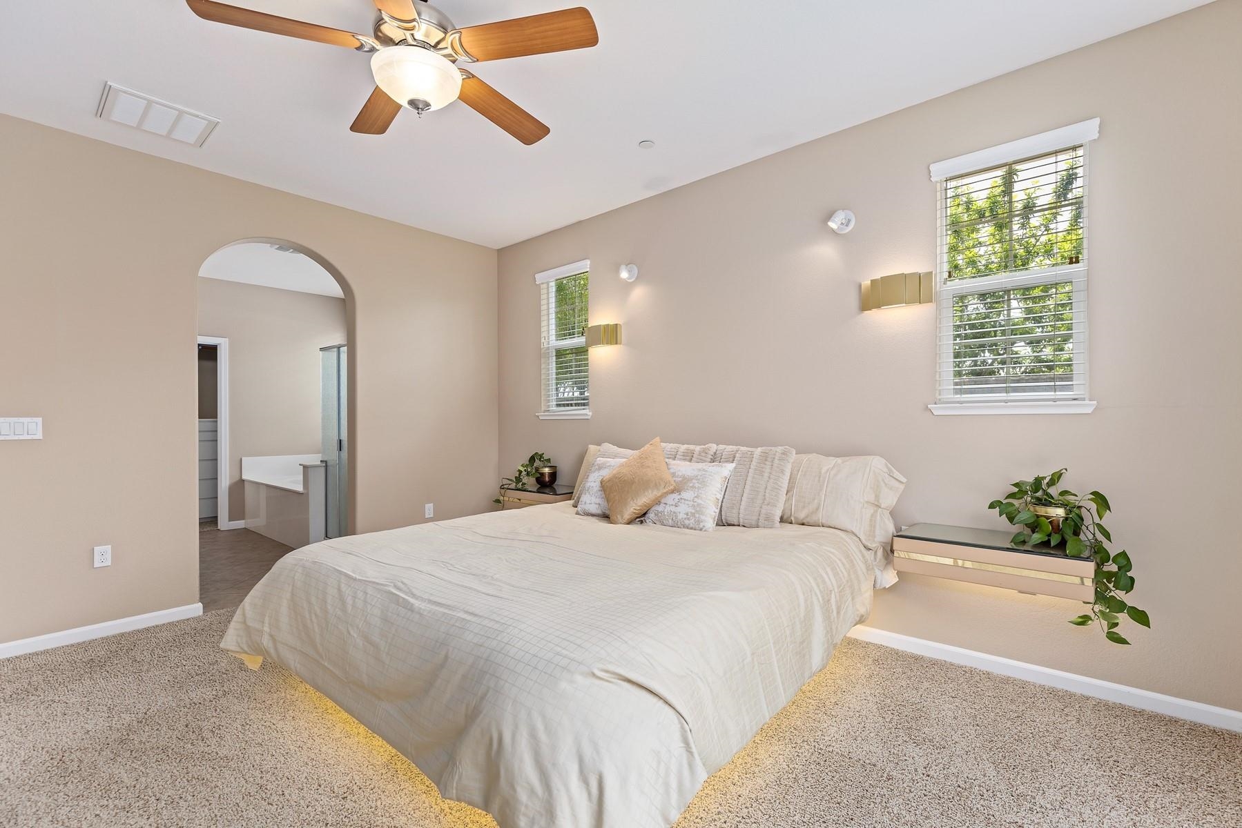 9901 Pyramid Way Discovery Bay, CA 94505 - Photo 25 of 53 a bedroom with a large bed and a chandelier fan