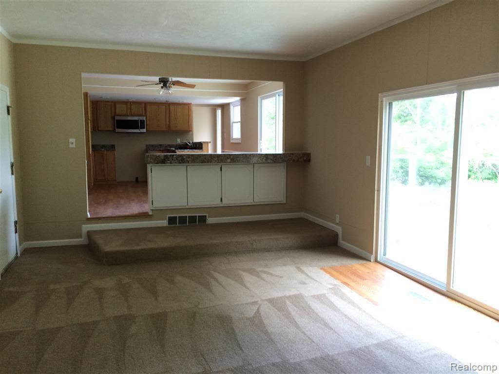 13045 White Lake Road Fenton, MI 48430 - Photo 10 of 30 Living room that is open with the kitchen area, with doorwall to patio.