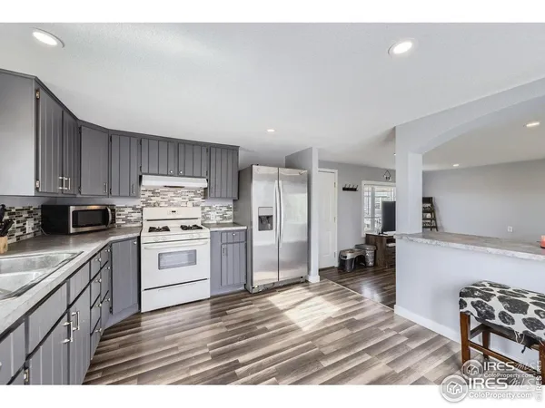 a kitchen with granite countertop a sink stove and cabinets