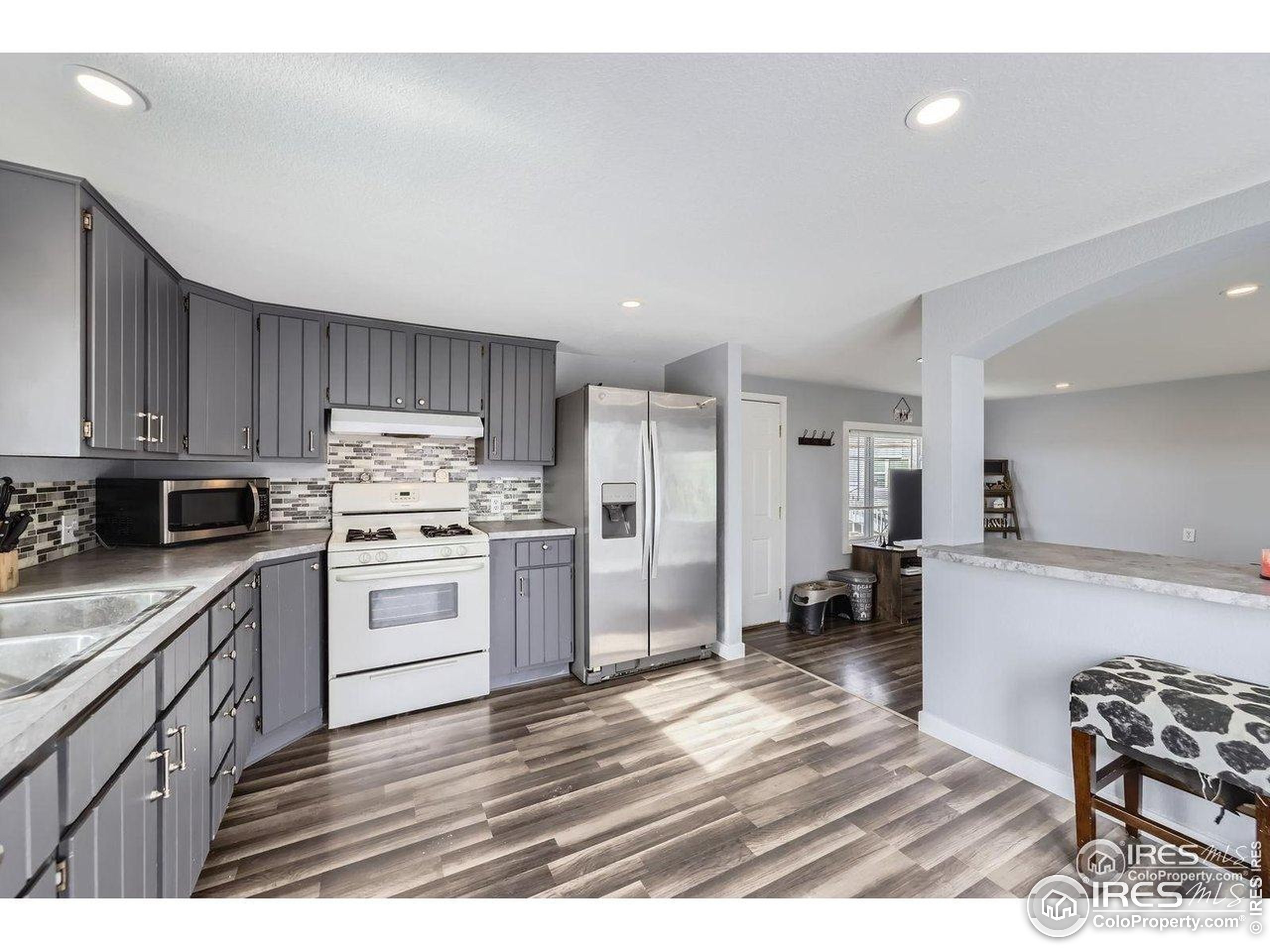 3500 35th Avenue, Unit 3 Greeley, CO 80634 - Photo 13 of 27 a kitchen with granite countertop a refrigerator cabinets and wooden floor