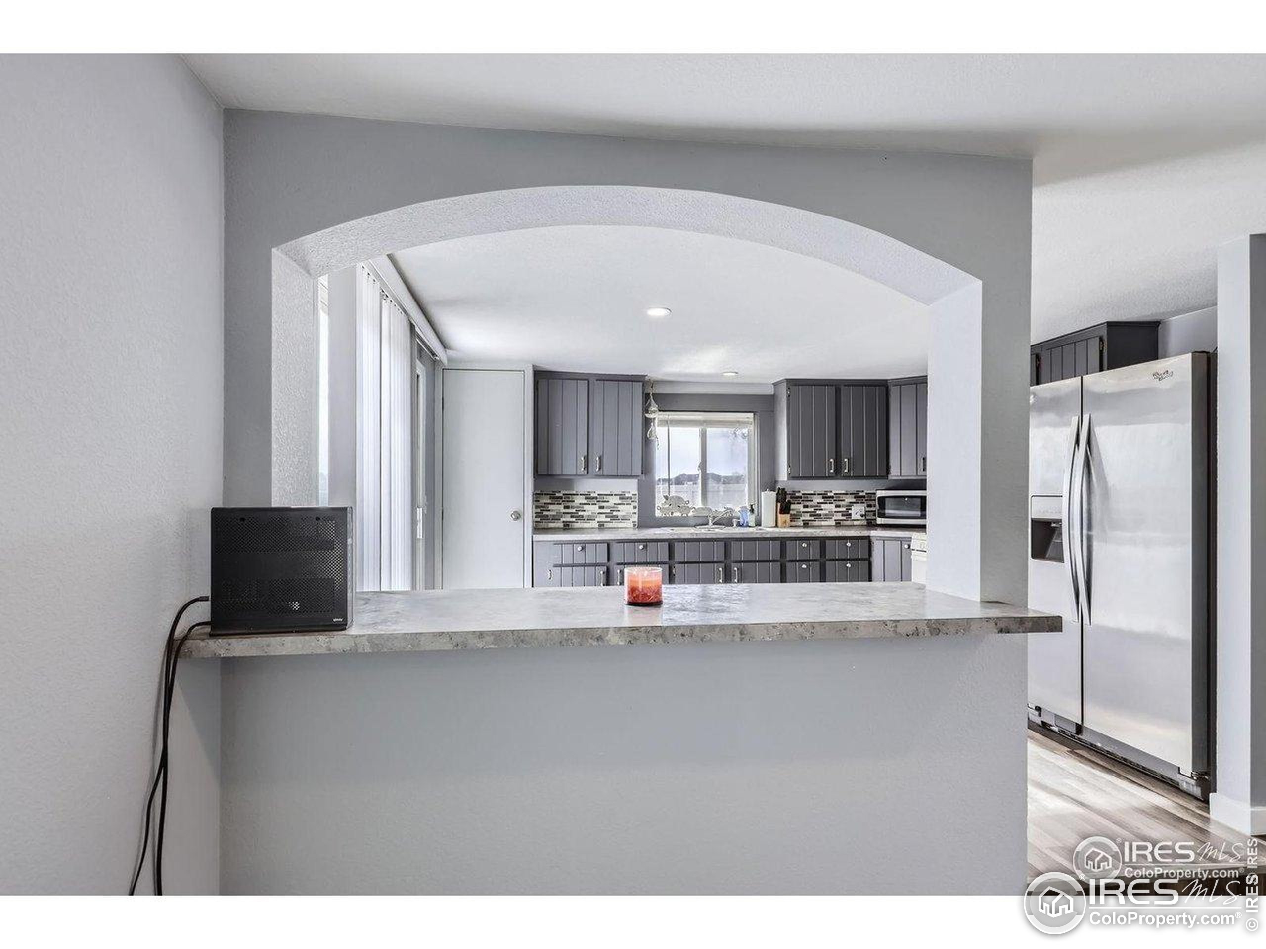 3500 35th Avenue, Unit 3 Greeley, CO 80634 - Photo 17 of 27 a living room with stainless steel appliances kitchen island granite countertop a refrigerator a stove and a sink with wooden floor