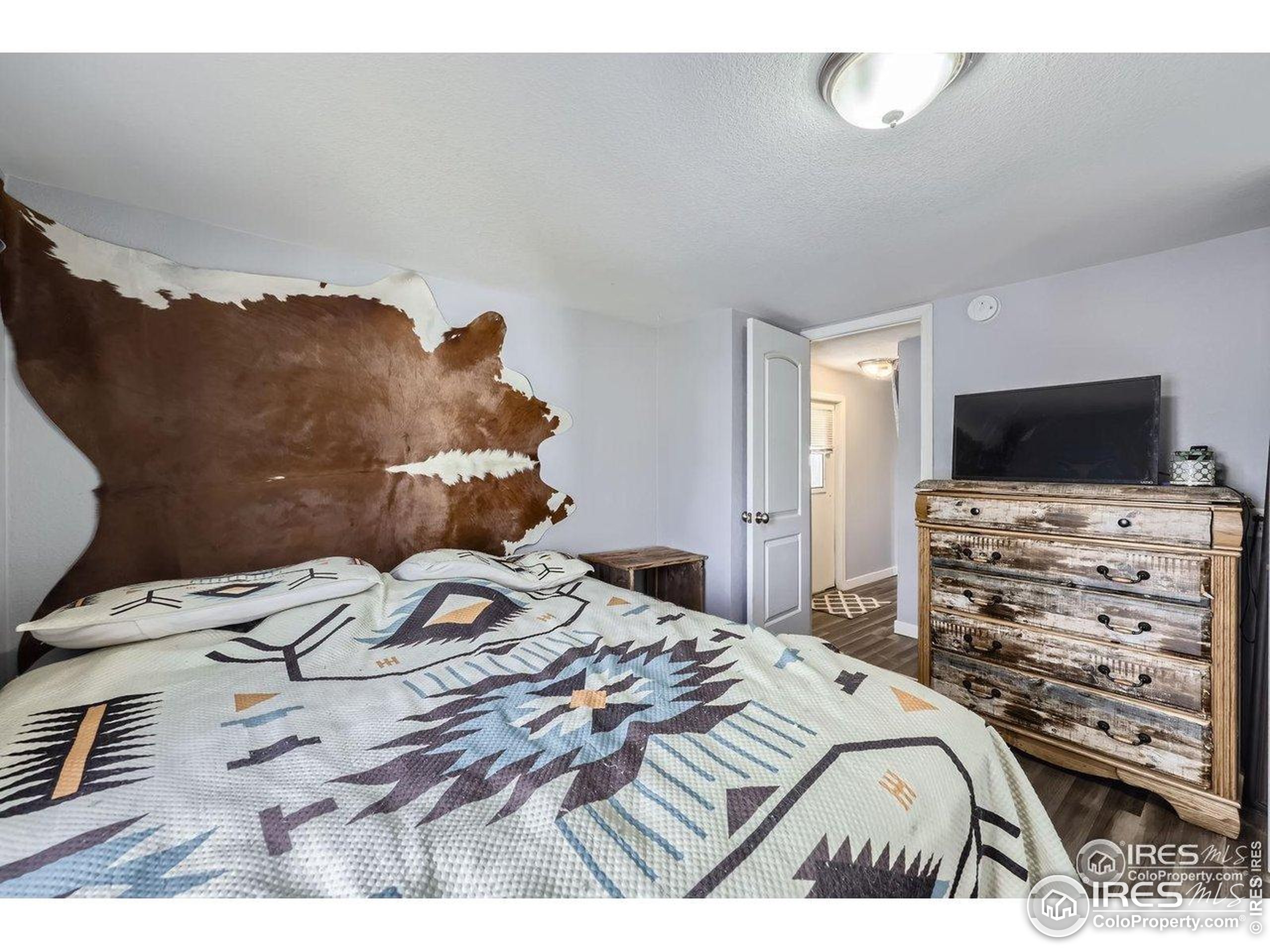 3500 35th Avenue, Unit 3 Greeley, CO 80634 - Photo 20 of 27 a bedroom with a bed and a flat screen tv