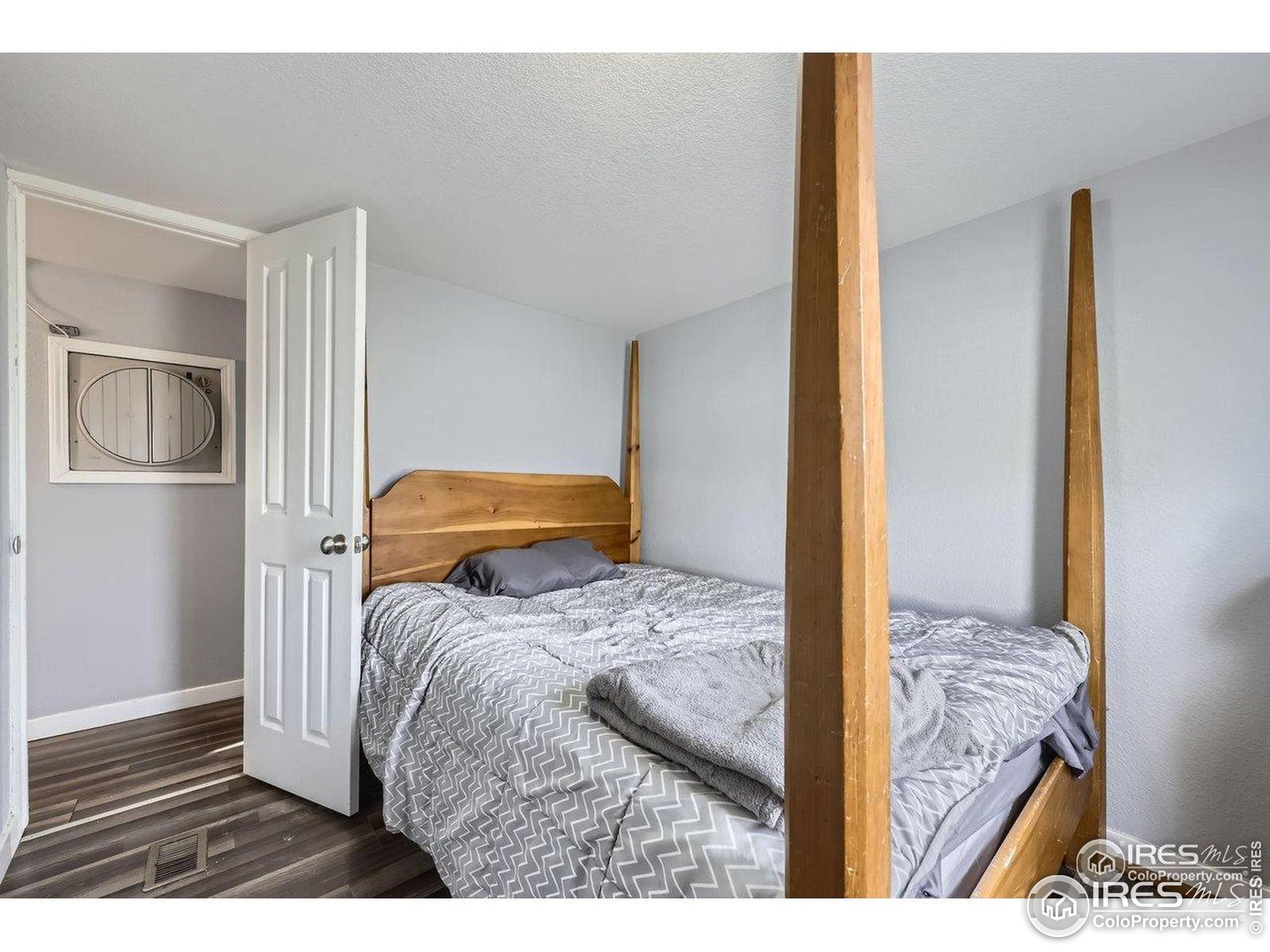 3500 35th Avenue, Unit 3 Greeley, CO 80634 - Photo 23 of 27 a bedroom with a bed and wooden floor