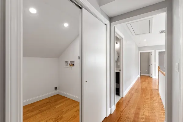 a view of a hallway with a room and wooden floor
