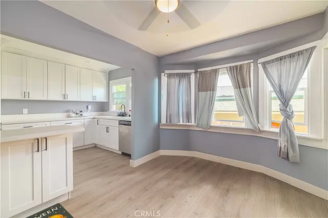 a kitchen with white cabinets and a window