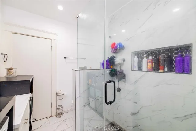 a bathroom with a shower sink vanity and mirror