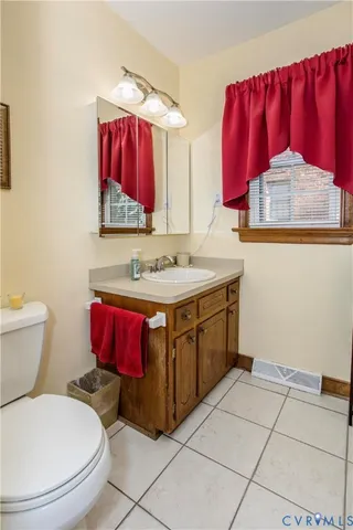 a bathroom with a toilet sink vanity and mirror