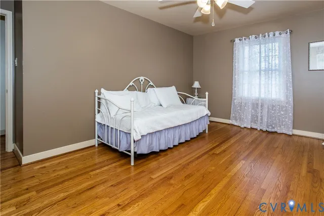 a bed sitting in a spacious bedroom next to a window