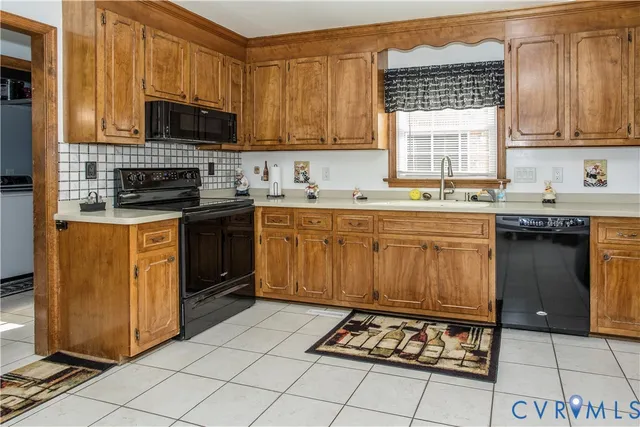 a kitchen with stainless steel appliances a sink a stove a microwave cabinets and a window