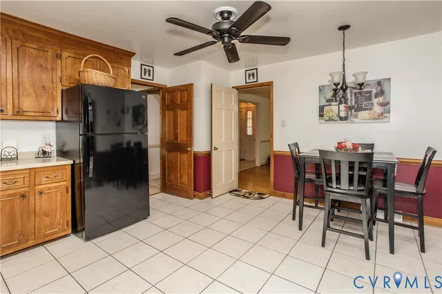 a kitchen with stainless steel appliances kitchen island granite countertop a refrigerator a stove a microwave oven with a dining table and chairs with wooden floor