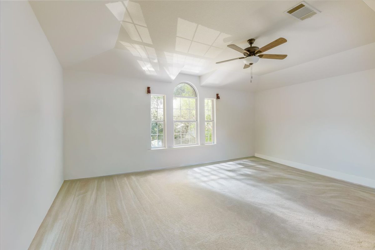 7136 Ridge Oak Road Austin, TX 78749 - Photo 19 of 28 Bright windows and soft carpeting define this spacious, serene primary bedroom.