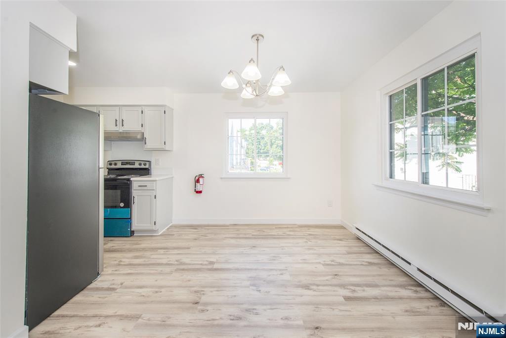 79 Getty Avenue, Unit 4B Clifton, NJ 07011 - Photo 21 of 30 an empty room with wooden floor a chandelier fan and windows